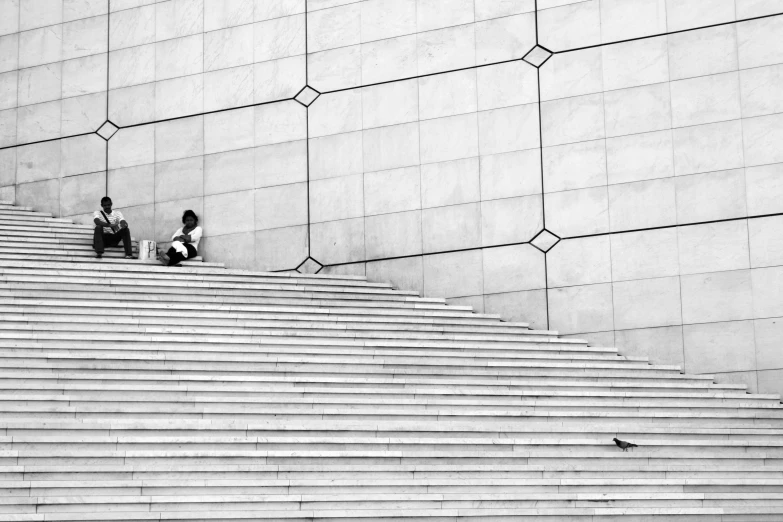 two people sitting on a cement set of stairs