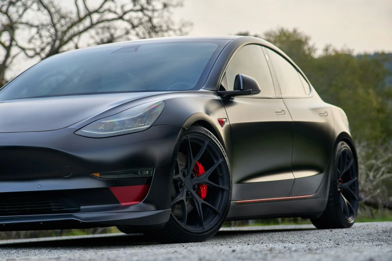 a black tesla - powered car parked on the street