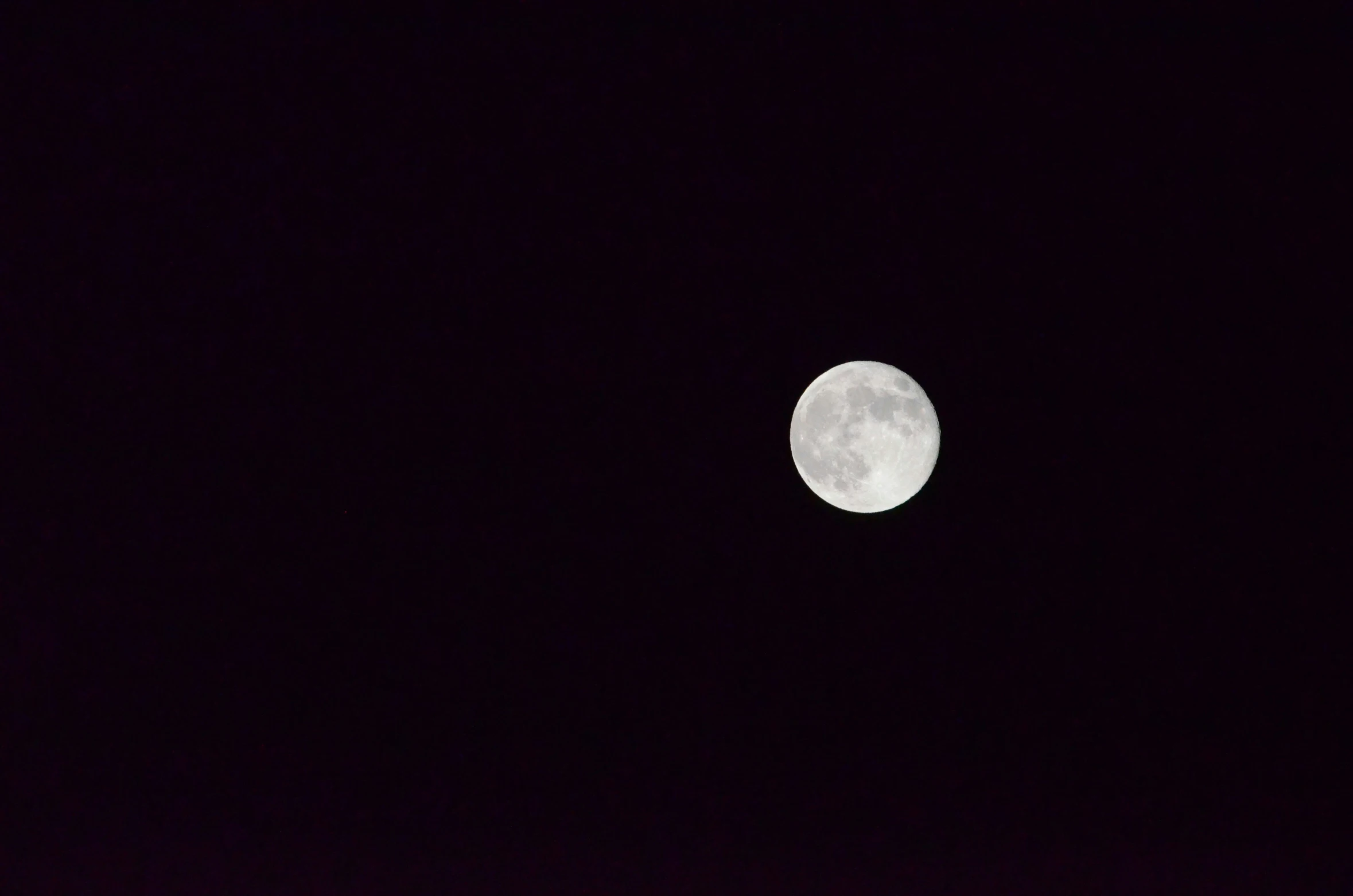 the full moon is seen behind a dark sky