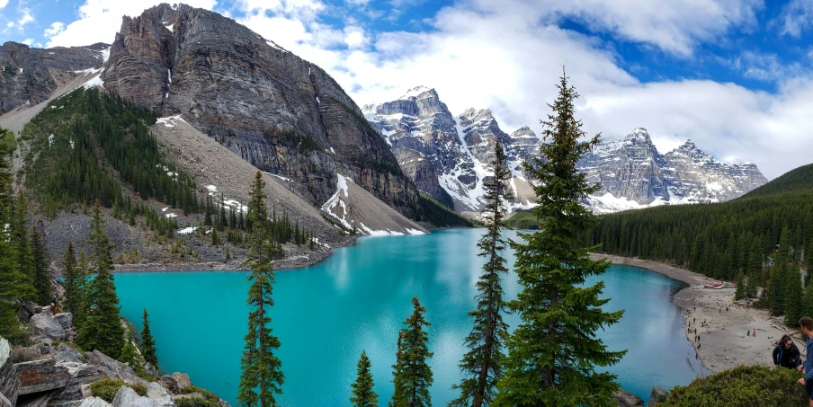 a blue lake surrounded by rocky mountains and pine trees