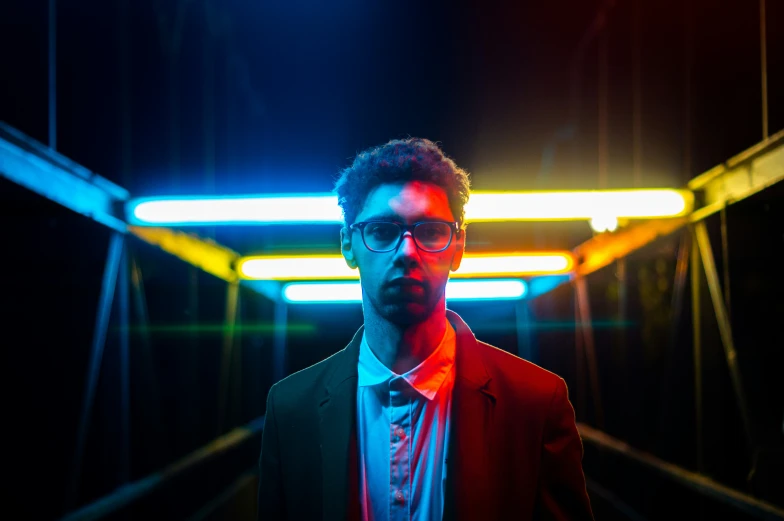 man in black suit and red shirt in a bright lit area