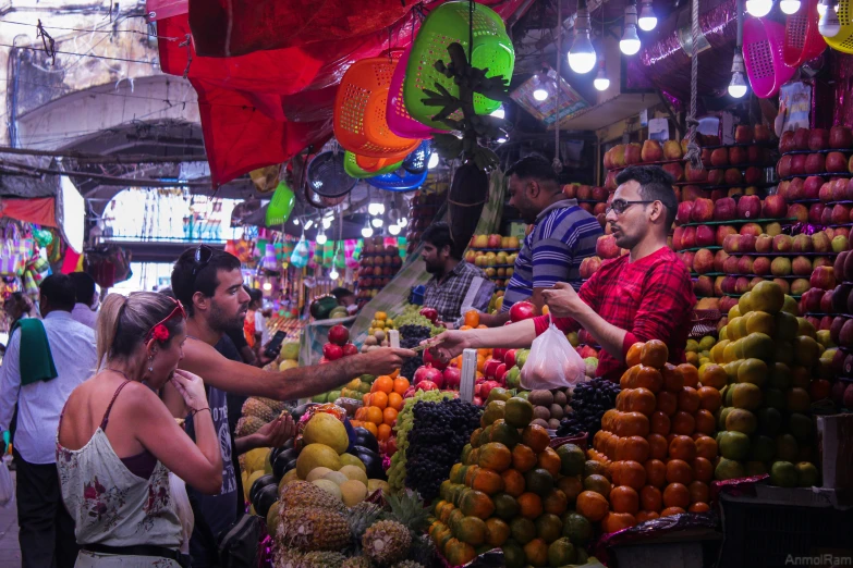 people shopping at an outdoor fruit and vegetable market
