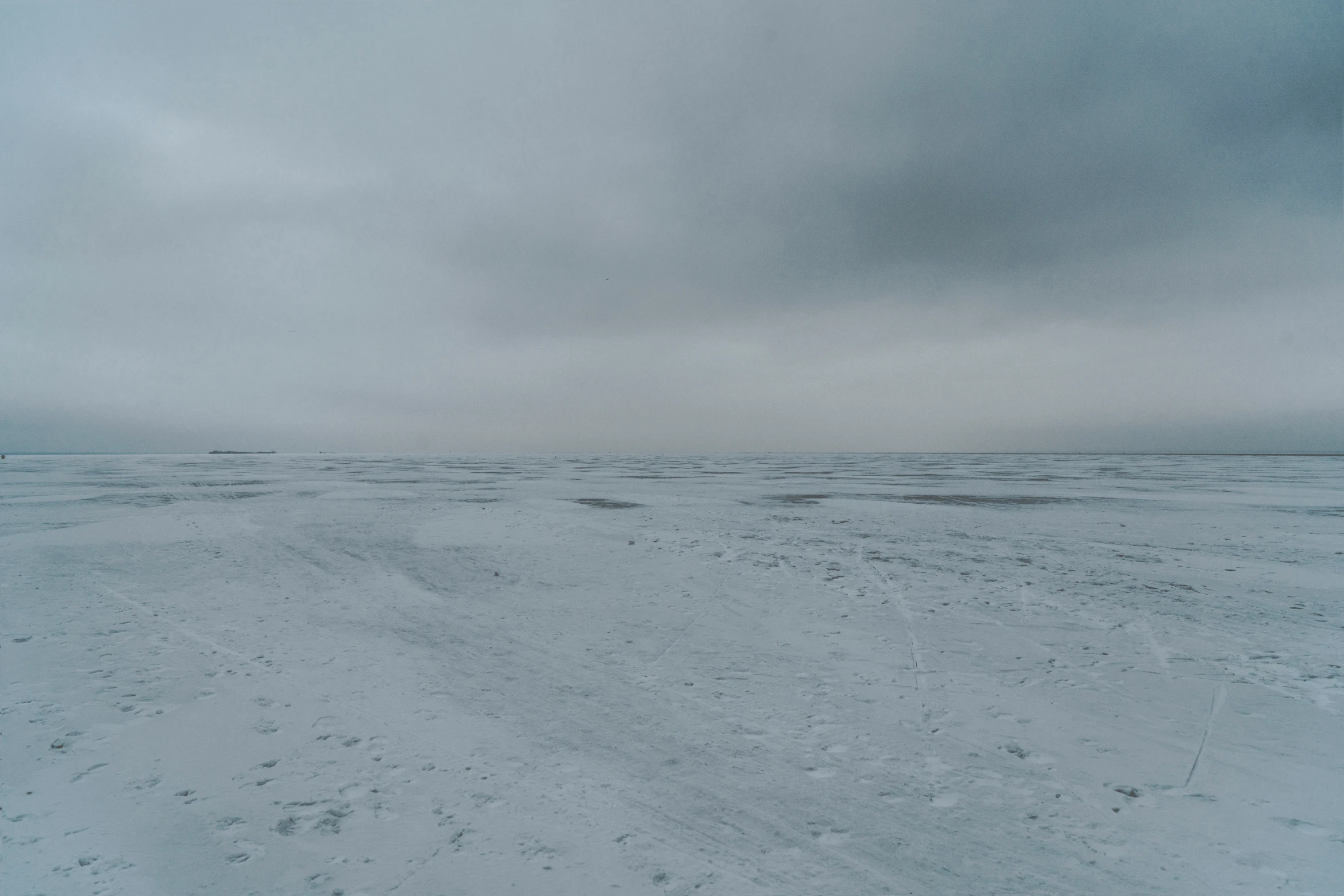 the desert looks almost barren with tracks in the snow