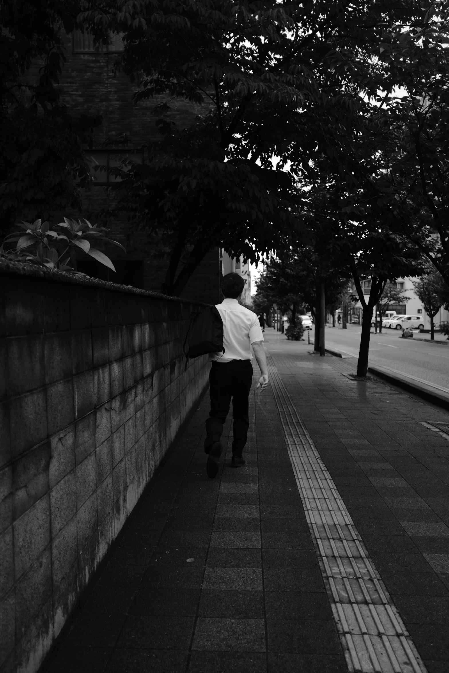 a person walking down a street next to a building