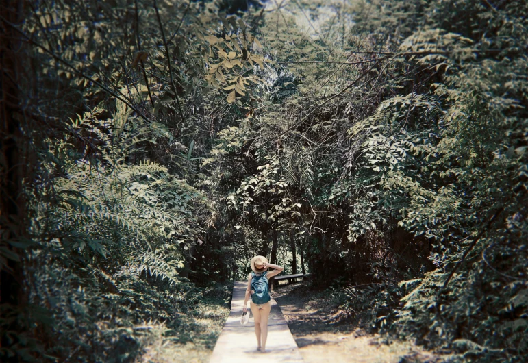 a woman walking in the woods next to a trail