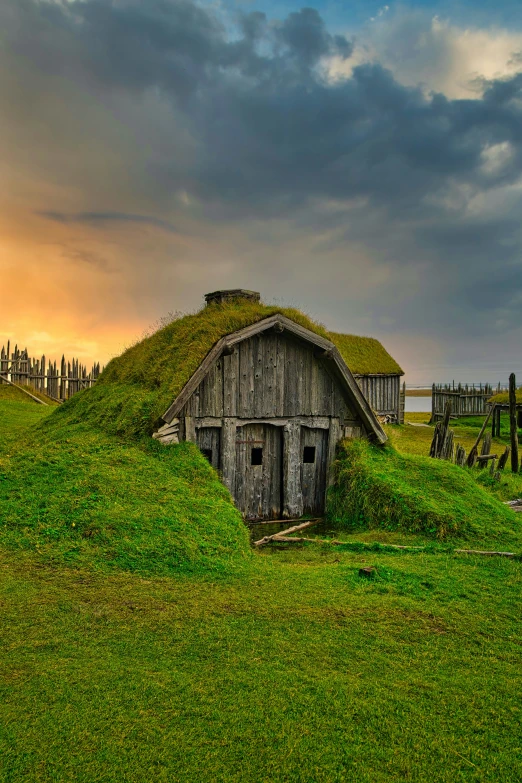 a grassy field has an old house on it