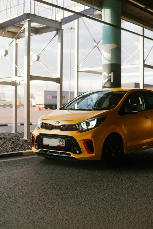 a small yellow car is parked in front of some large windows