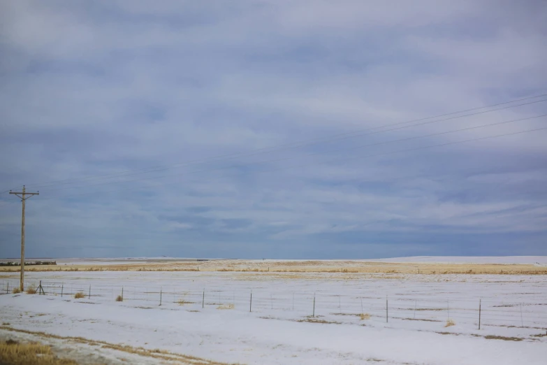 a road lined with lots of snow next to a field