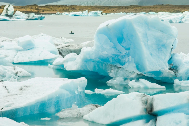 there is blue colored ice floating on the water