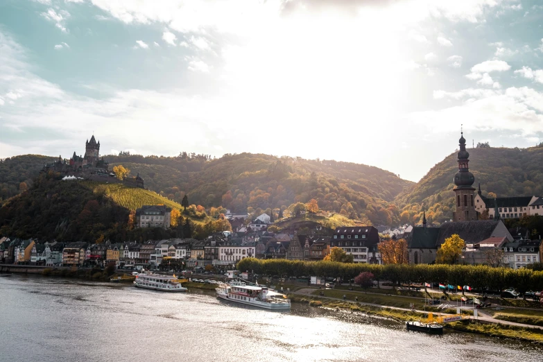 a river scene in autumn with boats traveling on it