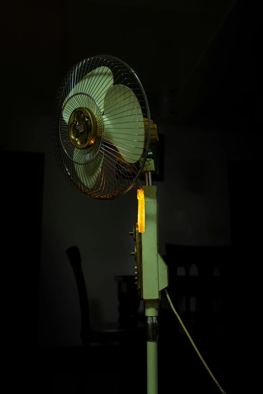 an electric fan on a desk in the dark