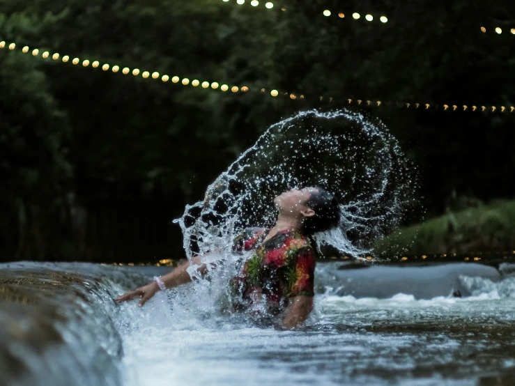 a lady in red is on the water with an umbrella