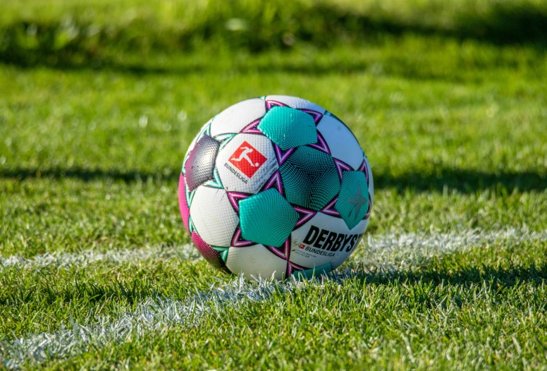 a soccer ball is on the ground and resting on the green grass