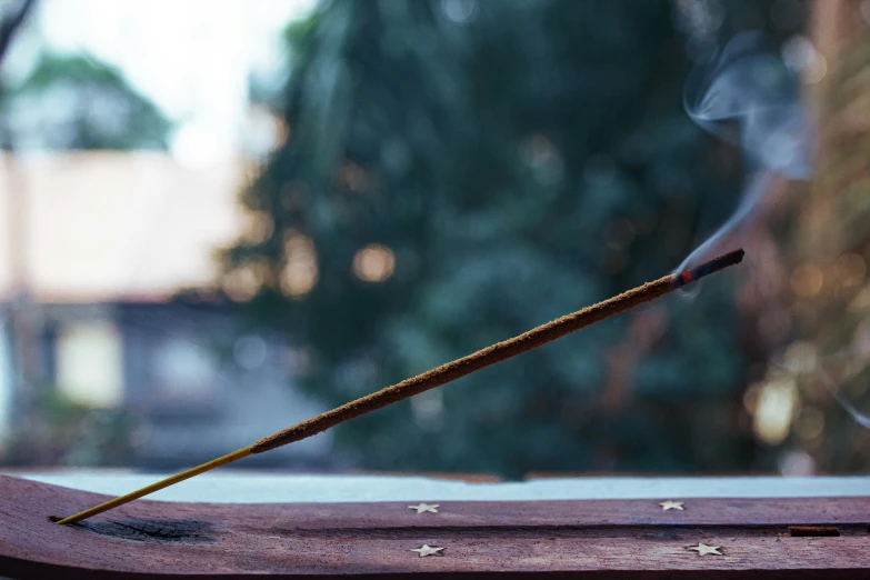 a white and black incense with its smoke coming out