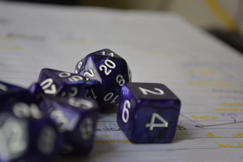 five blue and white dice sitting on top of papers