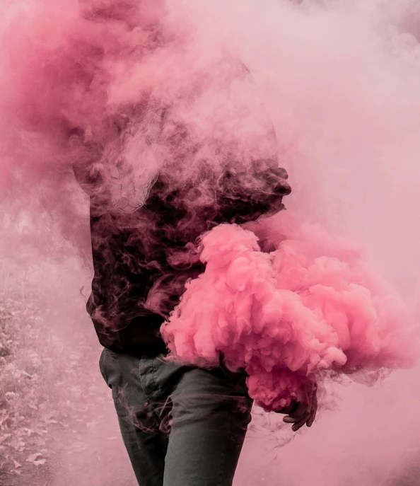 person standing in front of a pink smoke bomb