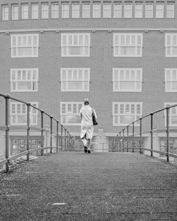 a man is walking up the stairs in front of the building