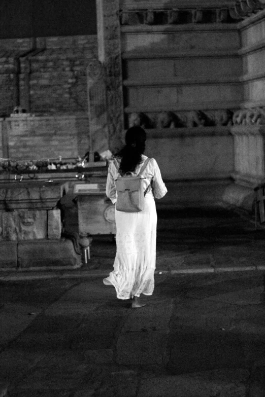 woman walking down the sidewalk in black and white