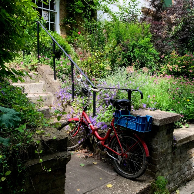 a red bicycle is sitting on a stone staircase