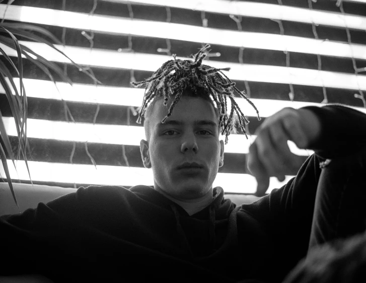 a man is holding a plant near the blinds