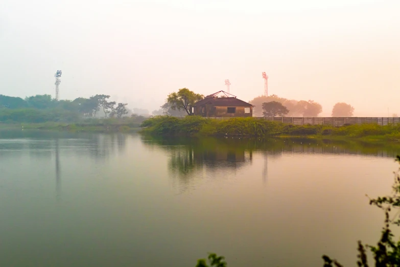 a lake in the foreground with an old train station sitting along it