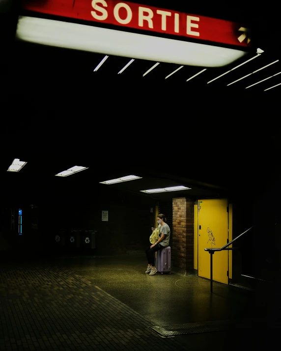 a person sitting on a box outside of the subway