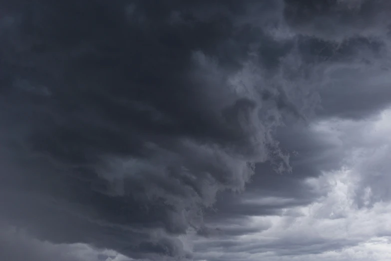 dark clouds loom over a black sea and rocky shoreline