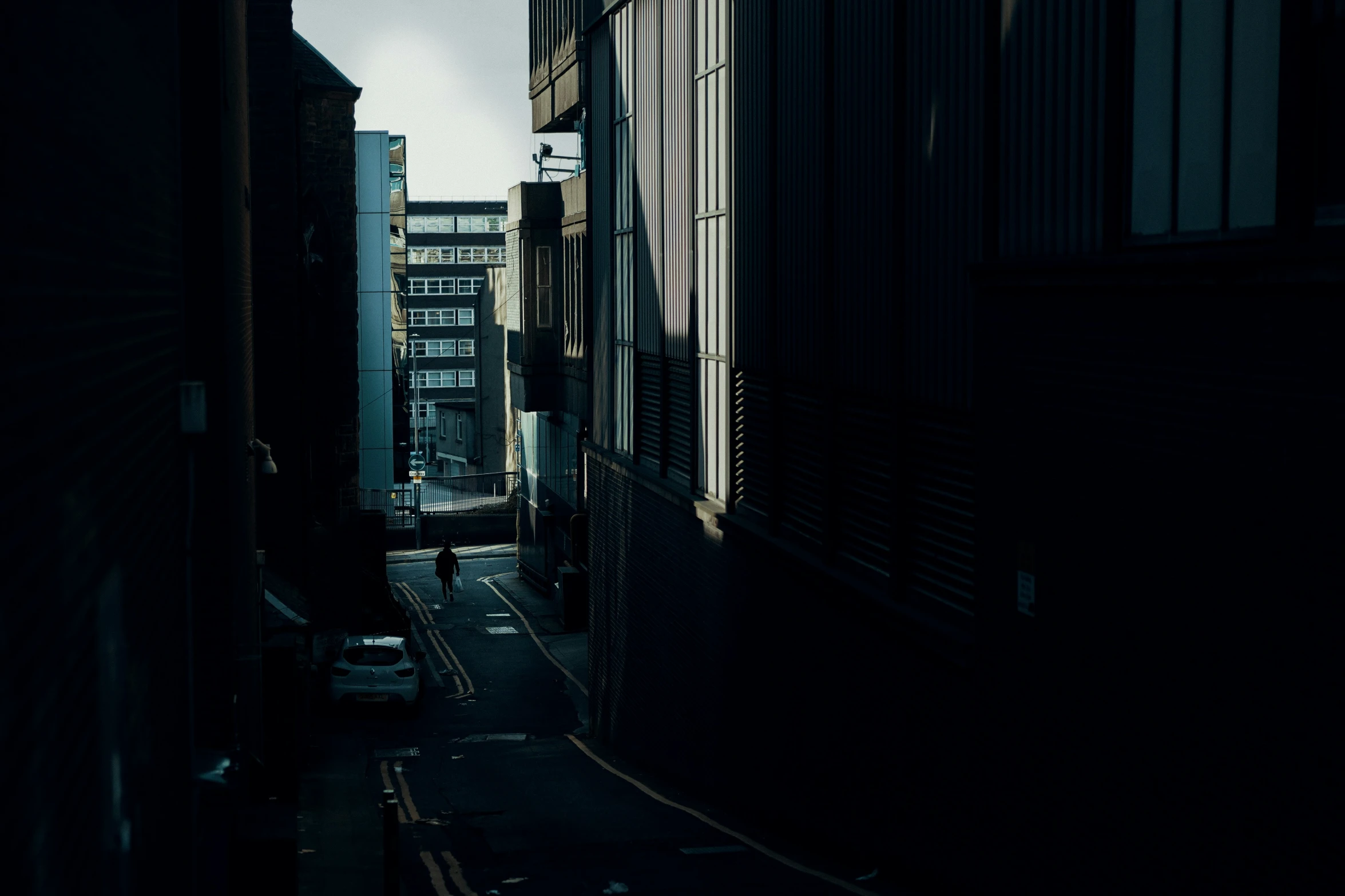 the shadows of two buildings and traffic are captured