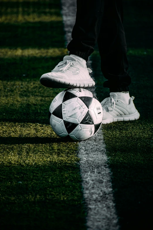 a person with his feet up on a soccer ball