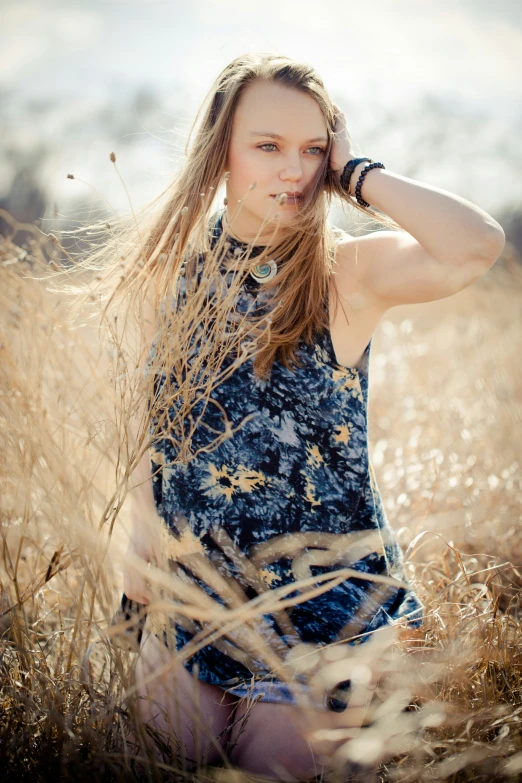 a beautiful young woman sitting in the grass