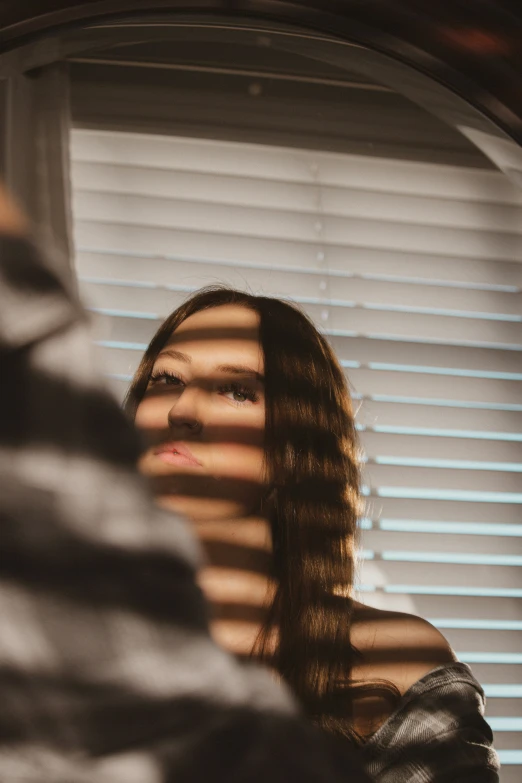 a woman is staring at her reflection in a mirror