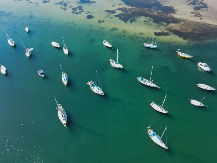 several boats in the ocean near a shoreline