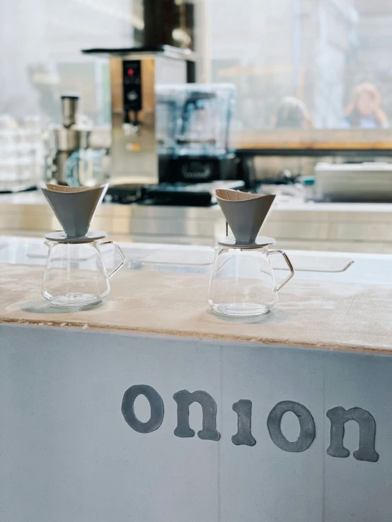 a counter with coffee cups on it in front of a window