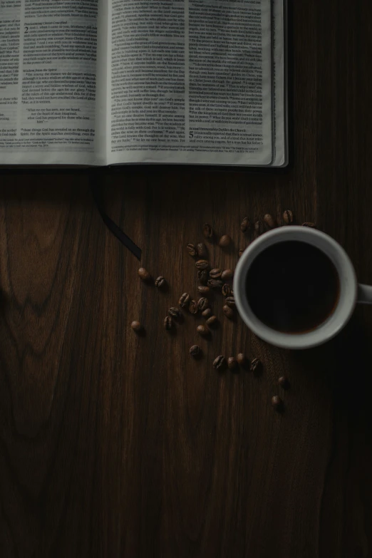 a bible open to read on a table with coffee and beans