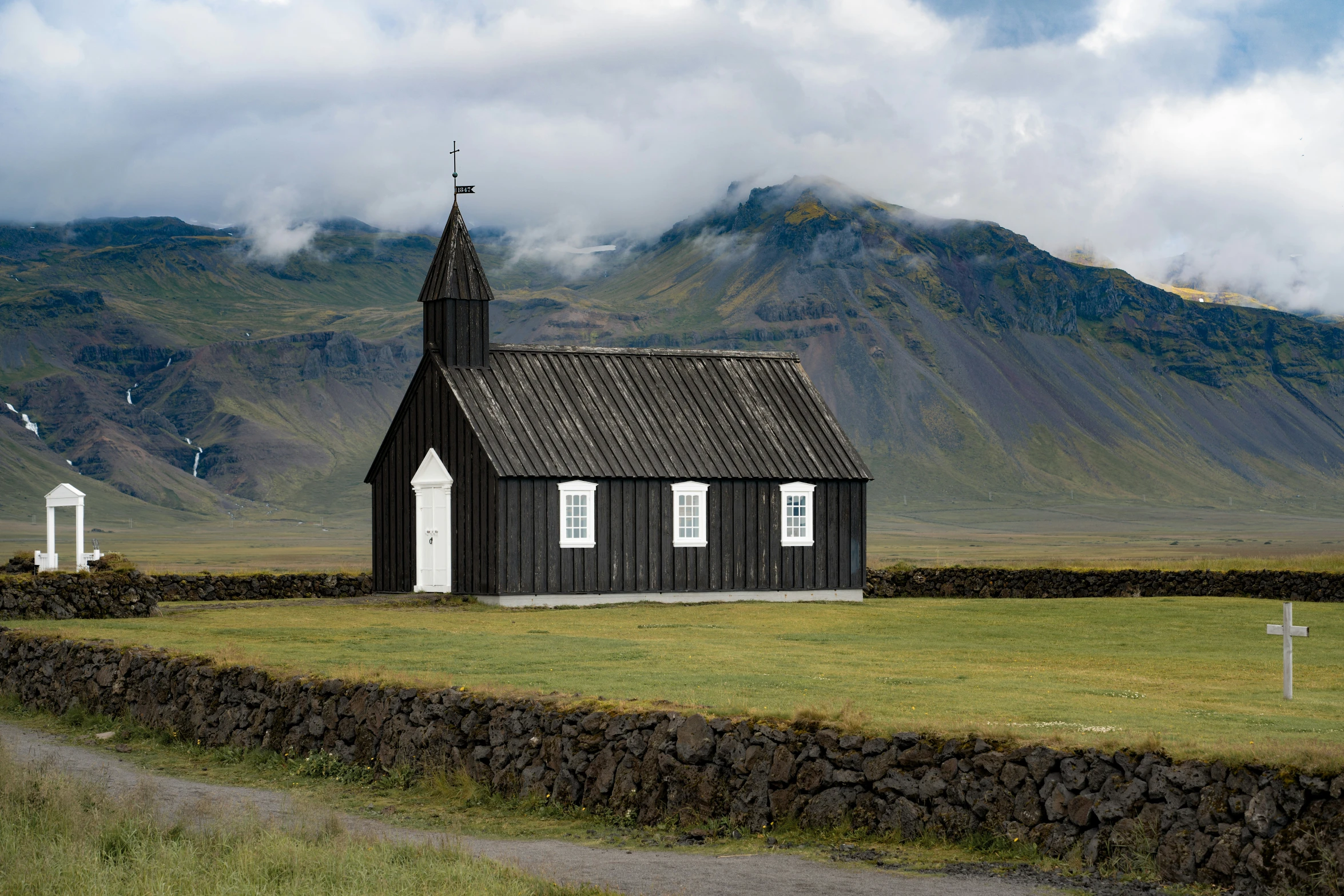 a black and white church is sitting in the middle of nowhere