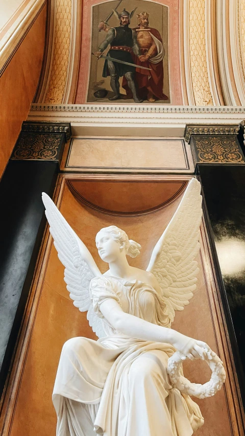 a statue with white wings in a cathedral