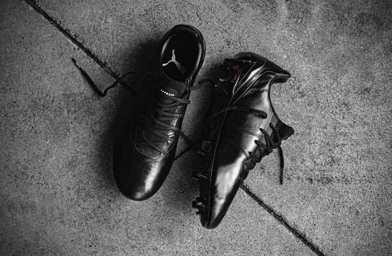 a pair of black soccer cleats on a floor