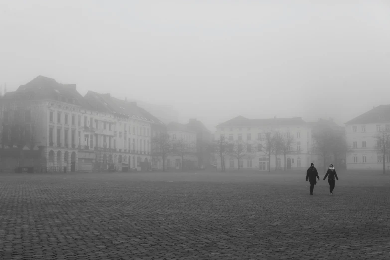 black and white po of people walking on cobblestone streets