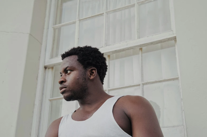 a man in a tank top poses for the camera