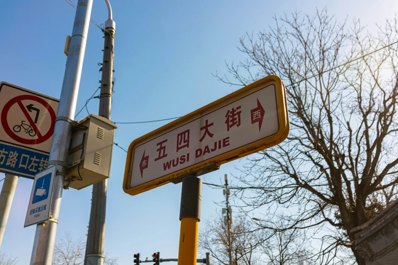 a street sign near other asian signs and traffic lights