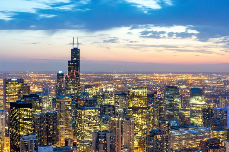 the top floors of many tall buildings lit up at night