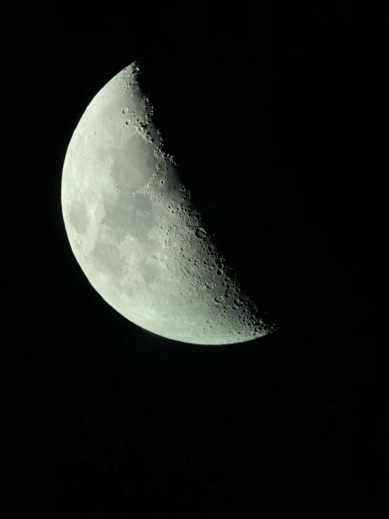 a half moon sitting in the black sky