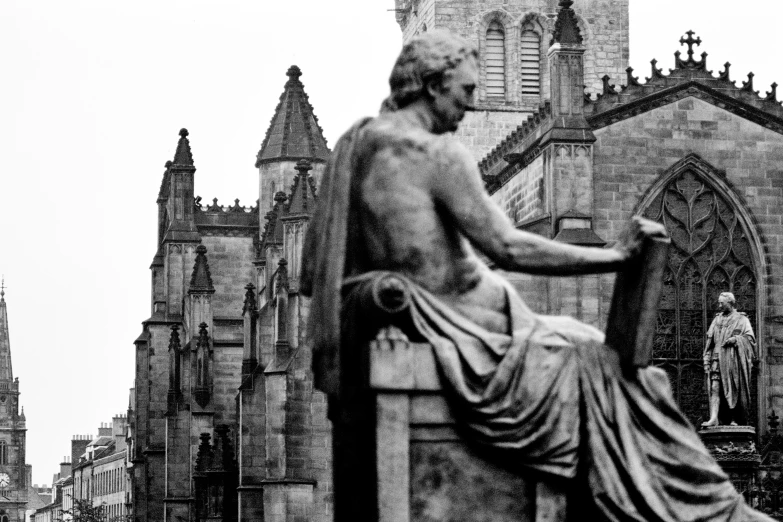 a statue of an old man seated on a bench