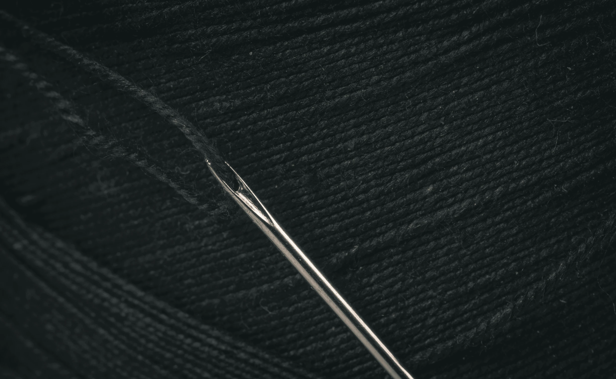 a black yarn with needles sticking out of it