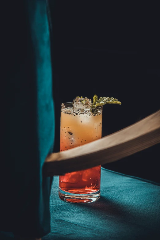 a drink sitting on a table next to an open book