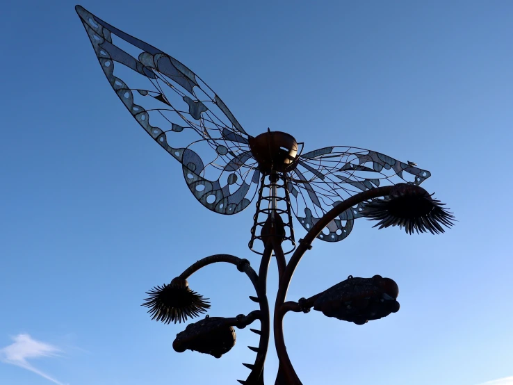 a decorative sunflower with wings and a street light