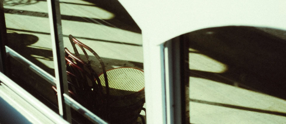 a reflection in a bus door of a window with a bunch of chair and basket on it