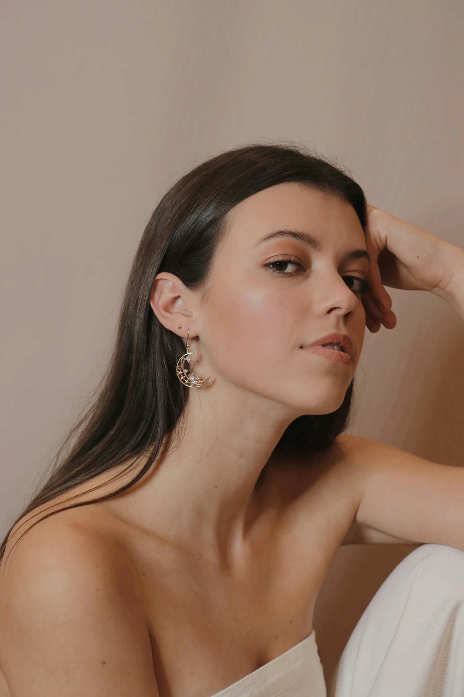 a woman is posing for the camera while wearing gold earrings