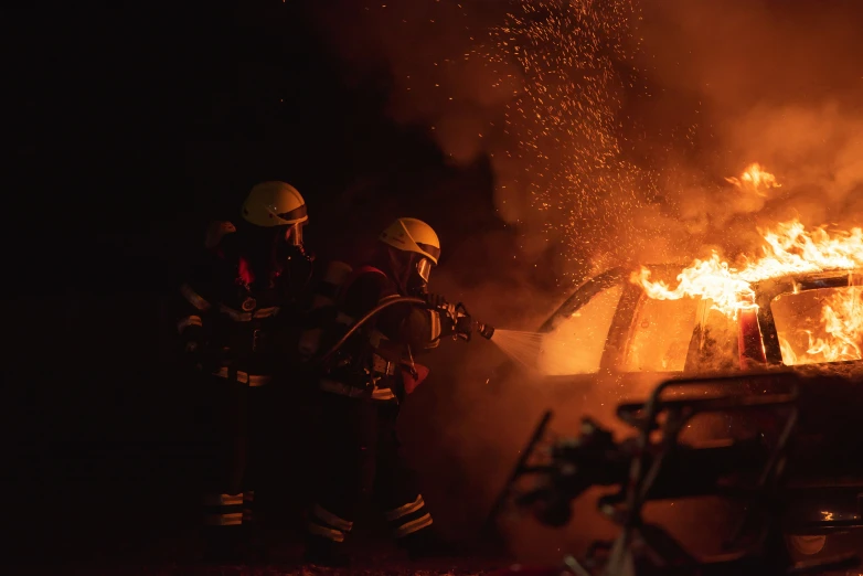 firemen work to put out a blaze at night