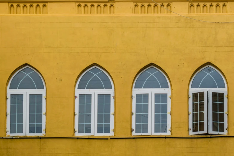 several windows are arranged together on a yellow building